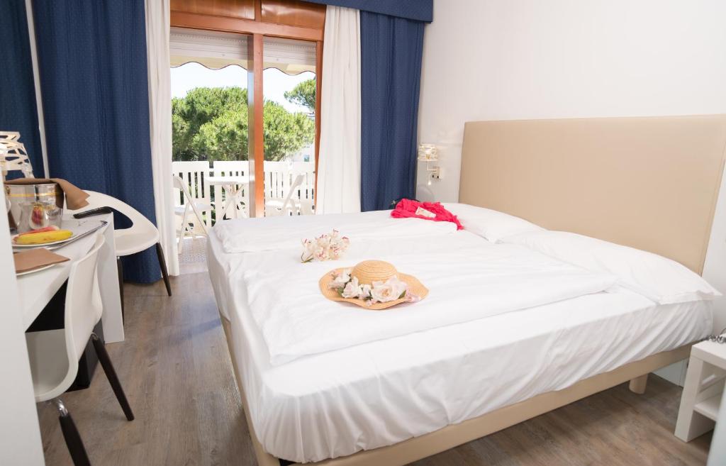 a bedroom with a bed with a plate of food on it at Fantinello Hotel in Caorle