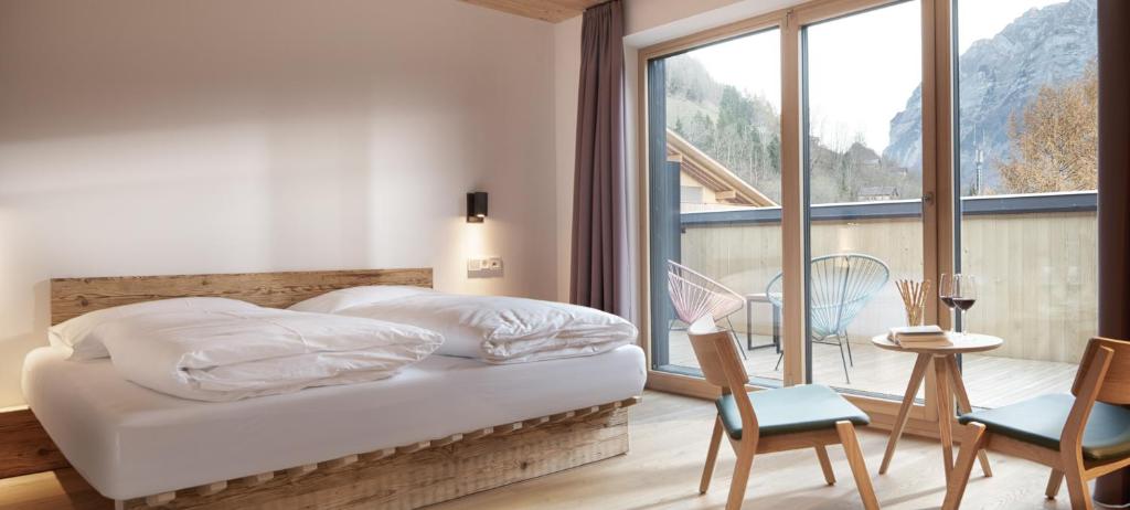 a bedroom with a bed and a large window at Hotel Bären in Mellau