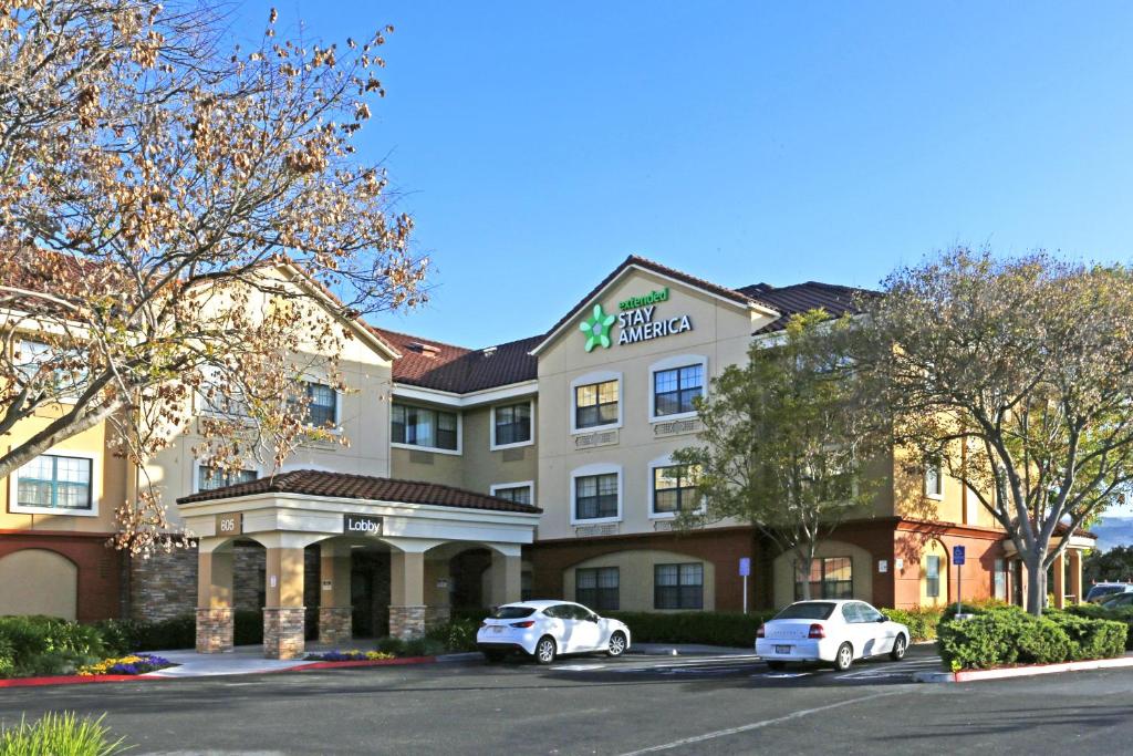 a hotel with two cars parked in a parking lot at Extended Stay America Suites - San Jose - Morgan Hill in Morgan Hill