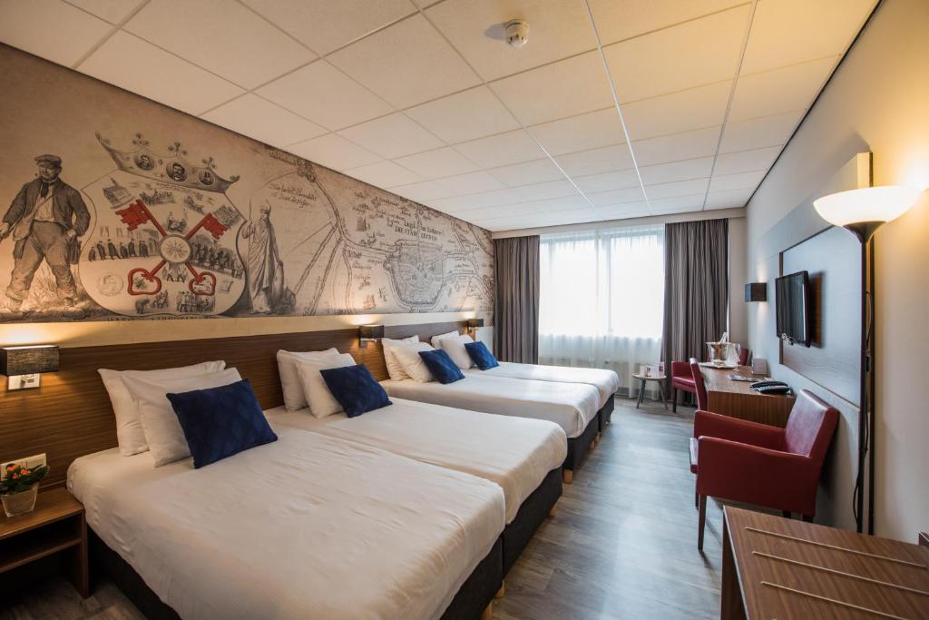 twee bedden in een hotelkamer met een muurschildering bij Tulip Inn Leiden Centre in Leiden