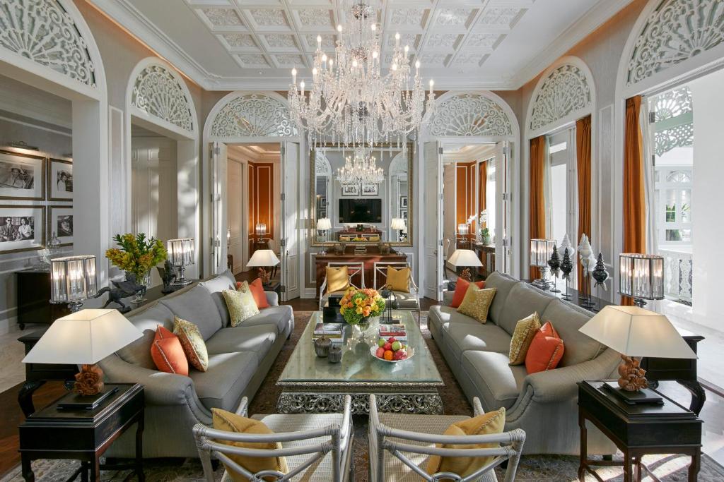 A grand salon with facing sofas, arched details and a large crystal chandelier.