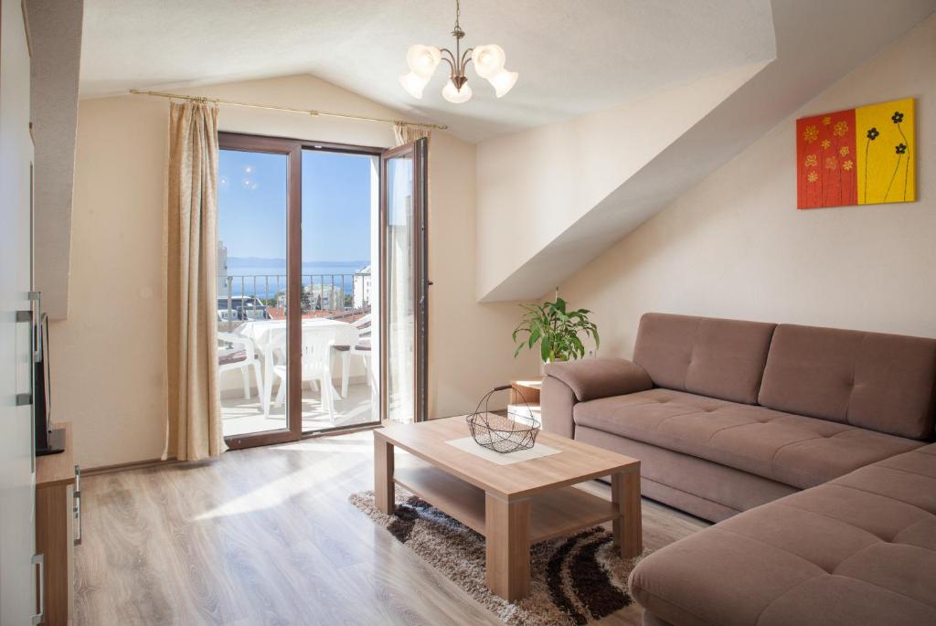 un soggiorno con divano e tavolo di Apartments Kate a Makarska