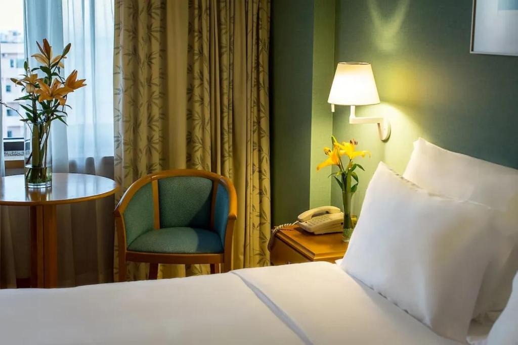 A single-bed room corner with a window seat area and traditional furnishings.