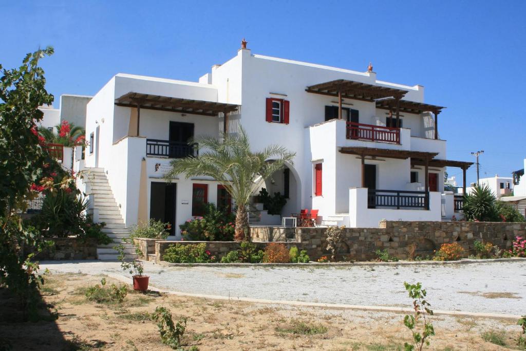a white house with a palm tree in front of it at Elisso's Philoxenia in Agios Prokopios