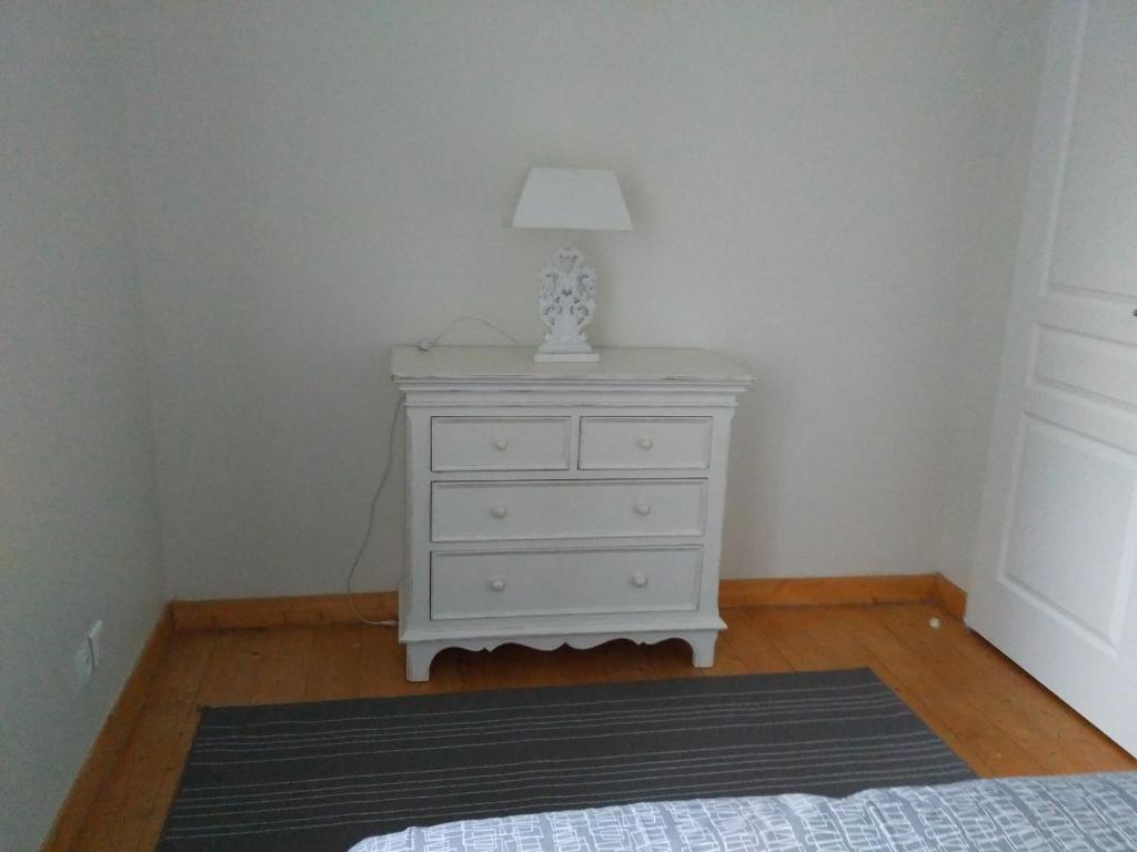 a bedroom with a white dresser with a lamp on it at Atelier Liberation in Bourgoin