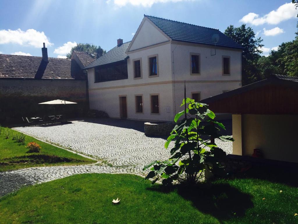 una gran casa blanca con un patio de guijarros en Prázdninový dům Vila 12 en Hořovičky