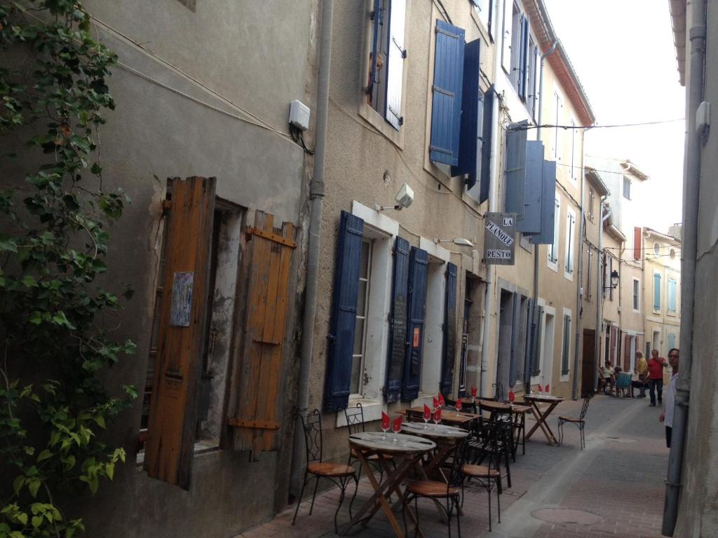 Une allée avec des tables et des chaises dans une rue dans l'établissement La planque, à Gruissan