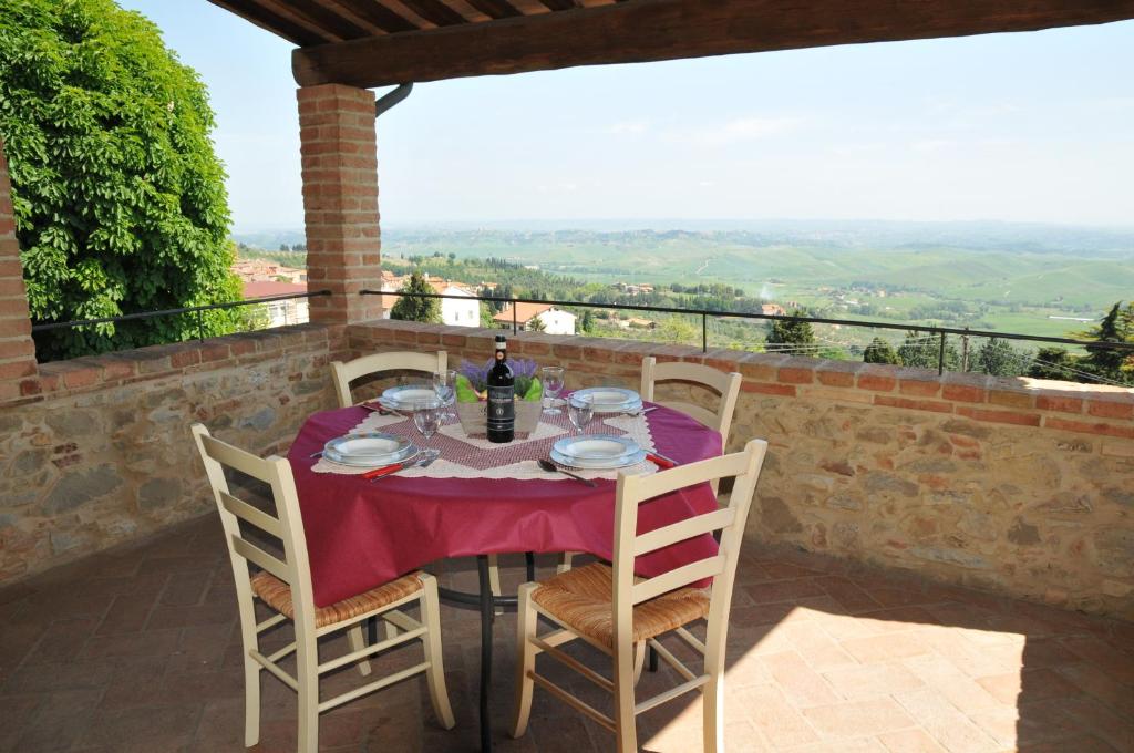 a table with a bottle of wine sitting on a patio at La Terrazza in Chianni