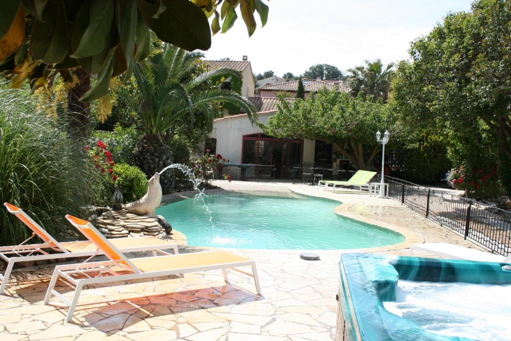 a swimming pool with two lawn chairs and a fountain at Villa Myami in Sanary-sur-Mer