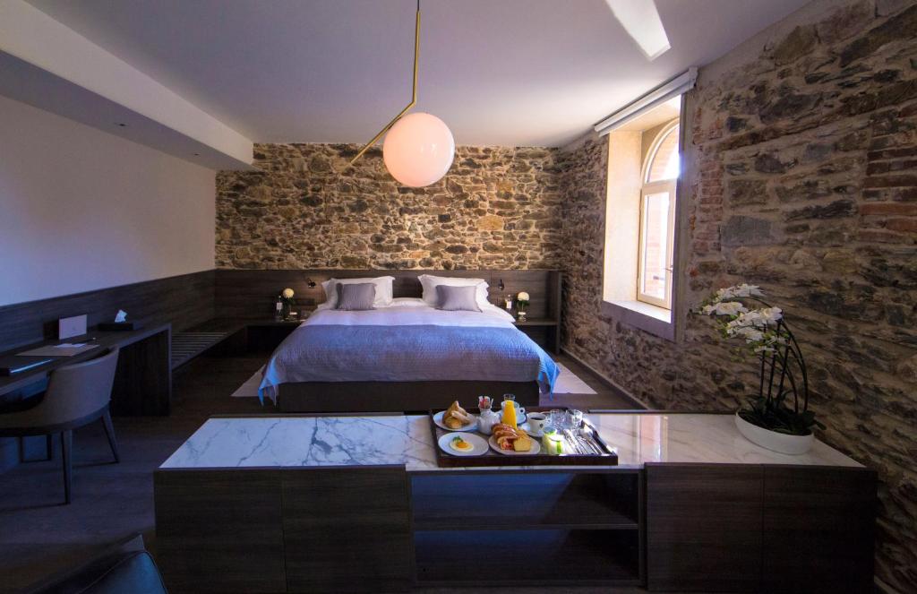 a hotel room with a bed and a table with food at Etoile de Pompadour in Arnac-Pompadour