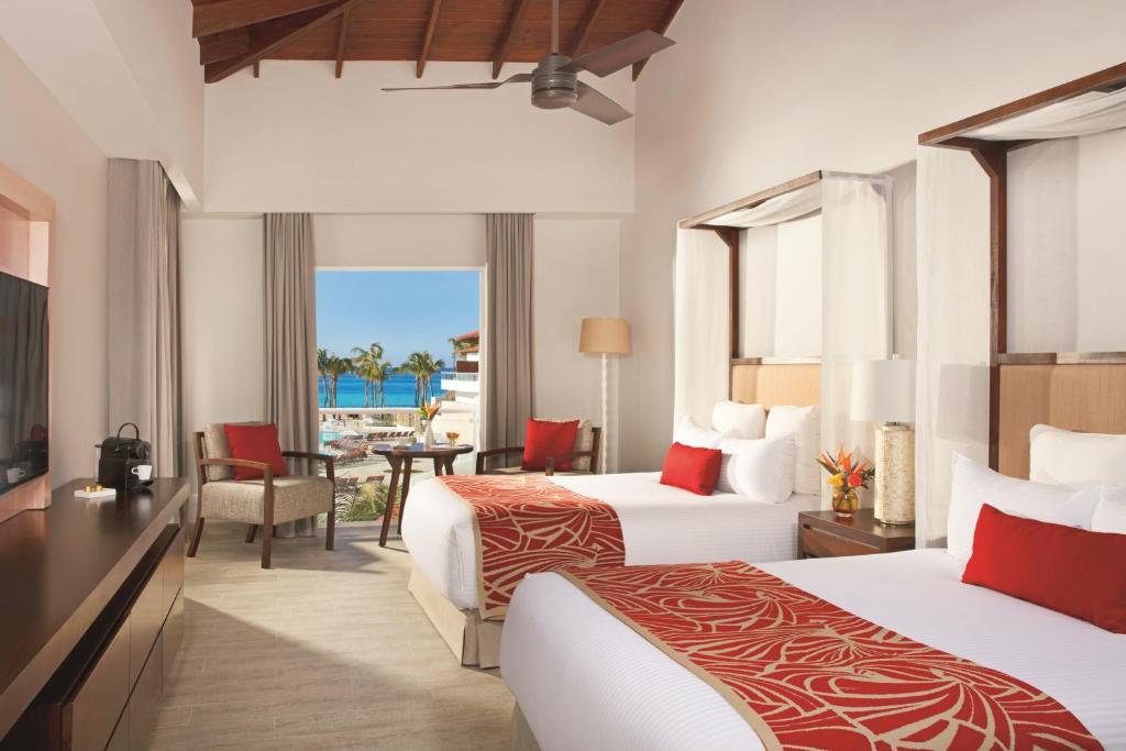a hotel room with two beds and a view of the ocean at Dreams Dominicus La Romana Resort & Spa in Bayahibe