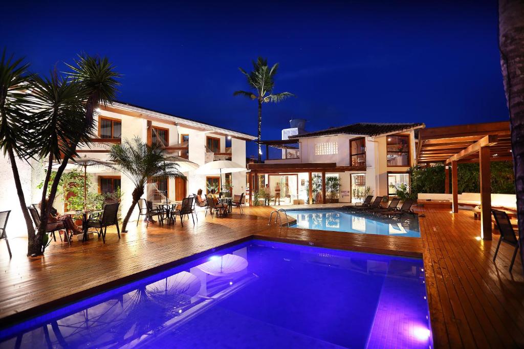 a house with a swimming pool at night at Flamingo Beach - Rede Soberano in Porto Seguro