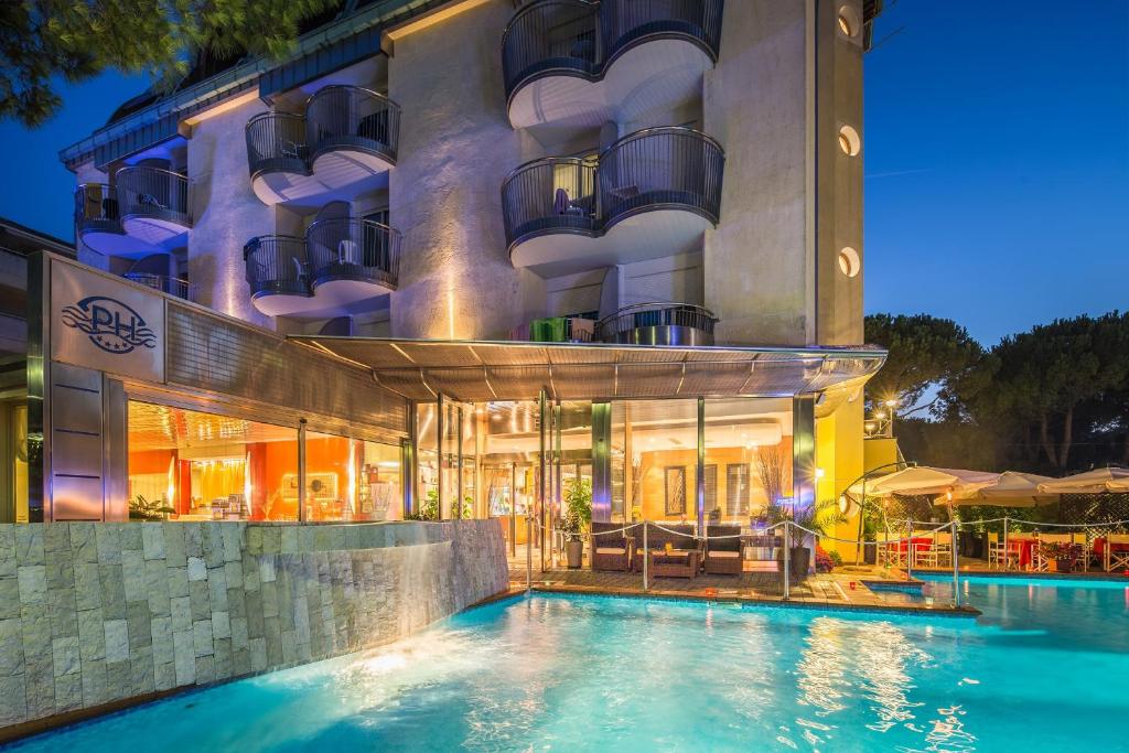 un hotel con piscina di fronte a un edificio di Park Hotel a Lignano Sabbiadoro