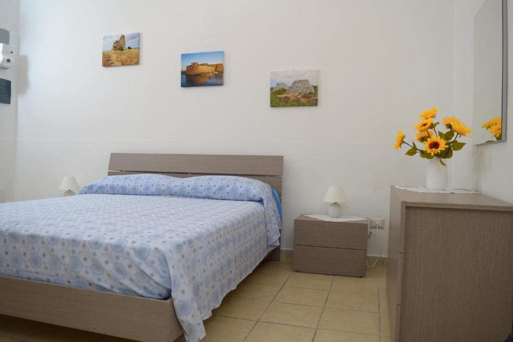 マティーノにあるLa Terra del Sole Casa privata per vacanzeのベッドルーム1室(ベッド1台、花瓶1本付)