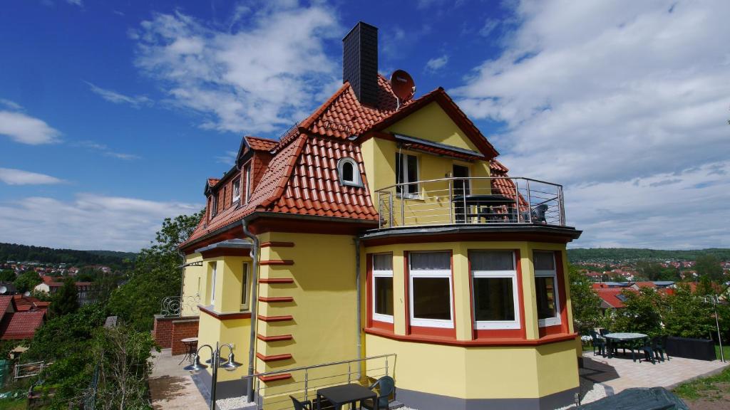 ein kleines gelbes Haus mit einem Dach in der Unterkunft Villa Am Ehrensteig in Eisenach
