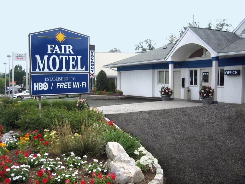 una señal para un motel justo frente a un edificio en Fair Motel en Upper Saddle River