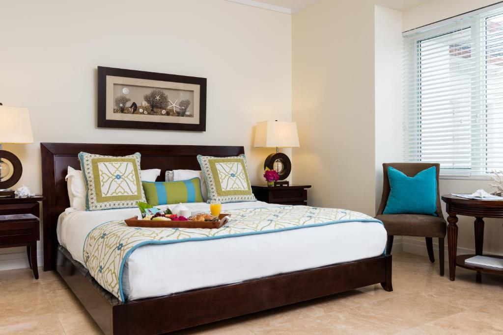 a bedroom with a bed with a tray on it at West Bay Club in Grace Bay