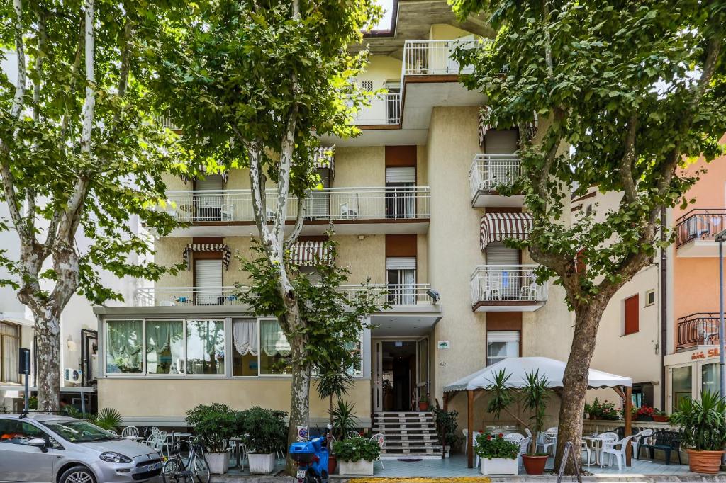 un edificio de apartamentos con árboles delante de él en Hotel Elisabetta 2 stelle en Cattolica