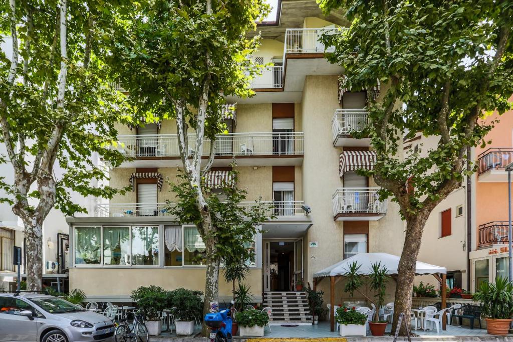 un condominio con alberi di fronte di Hotel Elisabetta 2 stelle a Cattolica