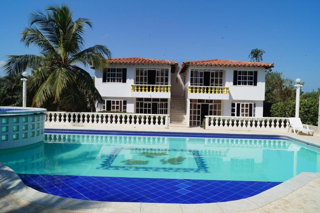 a villa with a swimming pool in front of a house at Condominio Punta Bolivar in San Antero