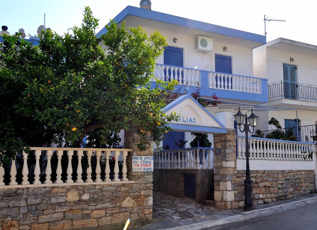 - un bâtiment blanc avec un balcon et une rue dans l'établissement Ilias Studios - Rooms, à Patitiri