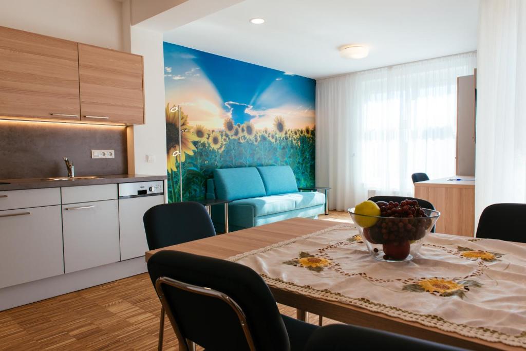 uma cozinha e sala de jantar com uma mesa com uma tigela de fruta em Aparthotel Heuberger em Rudersdorf