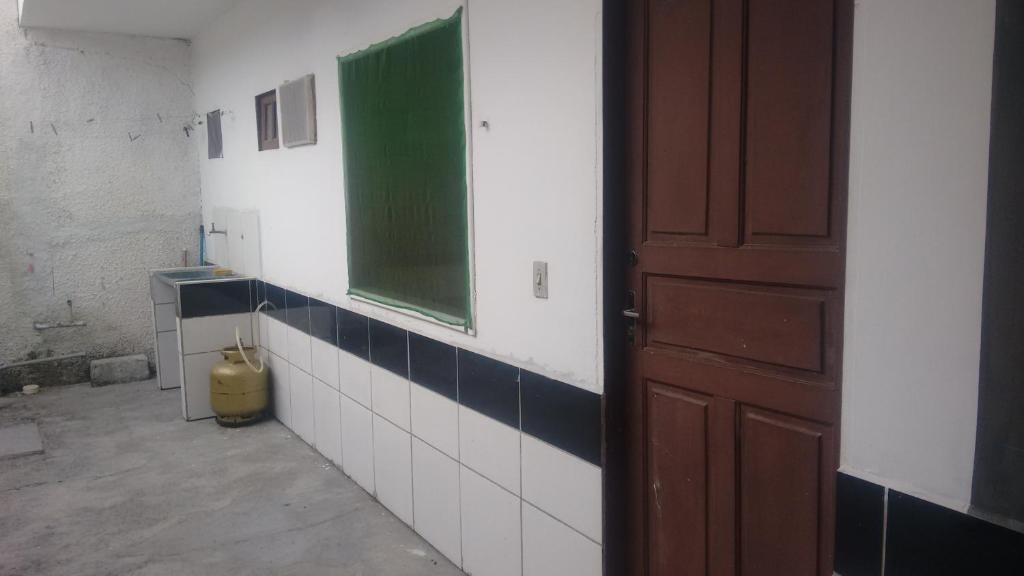a bathroom with a green window and a door at Hostel Tabapiri in Porto Seguro