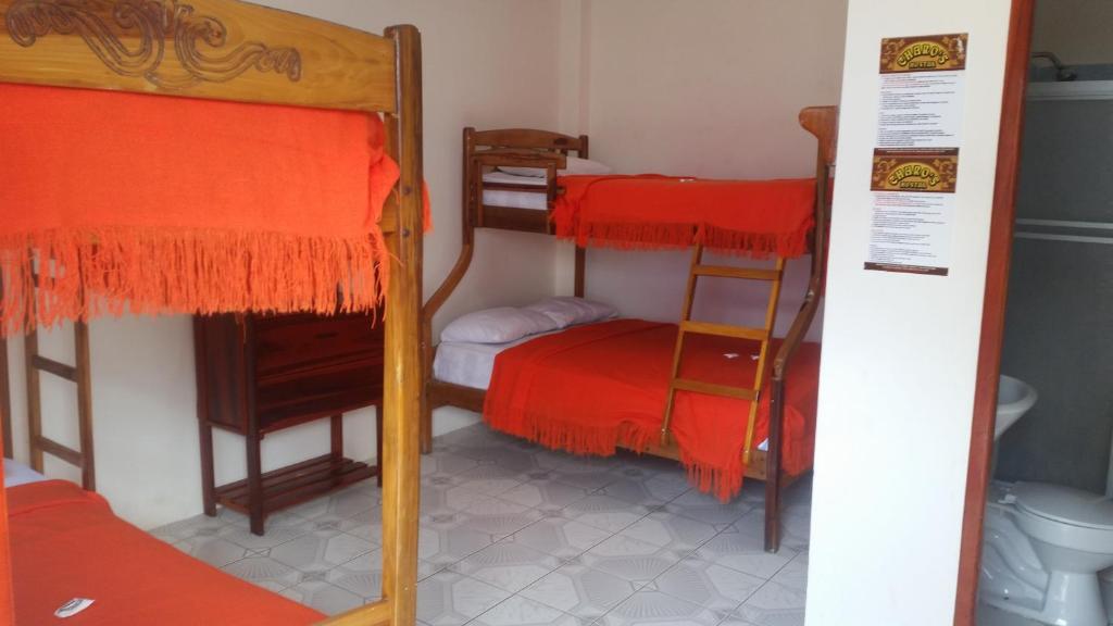 a room with two bunk beds and a toilet at Charo´s Hostal in Montañita
