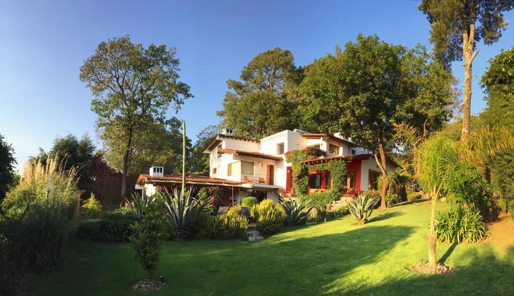 une maison dans une cour avec des arbres et de l'herbe dans l'établissement Las Luciernagas (Adults Only), à Valle de Bravo