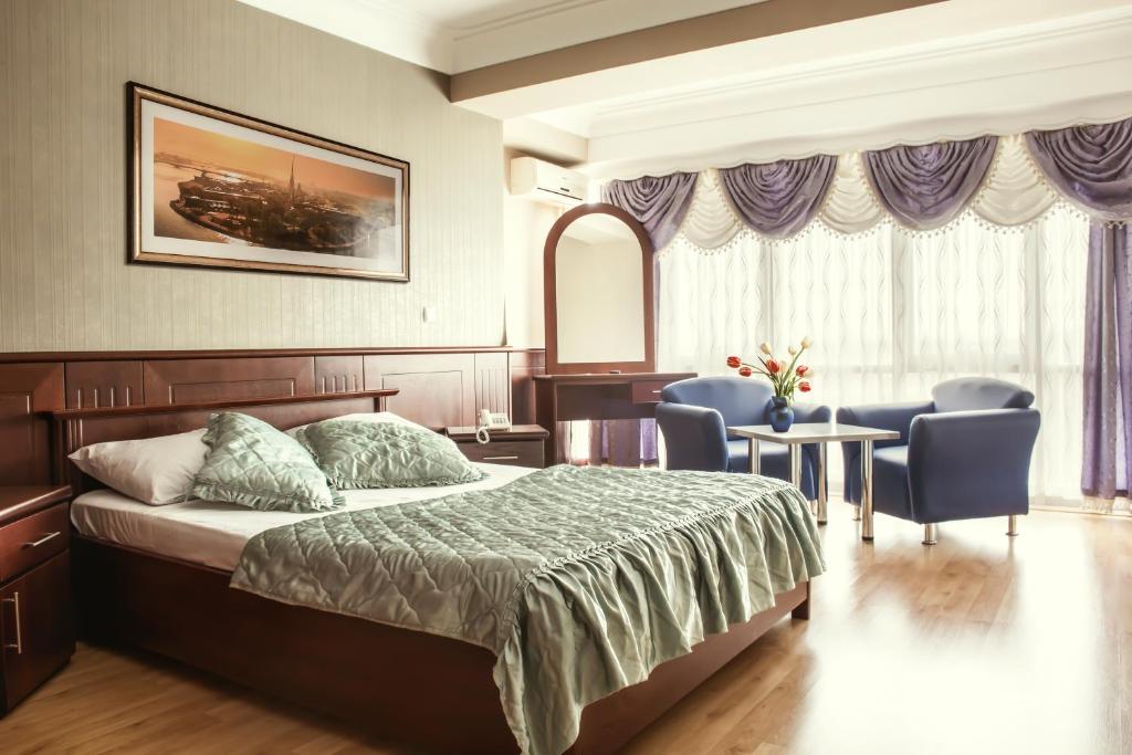 sypialnia z łóżkiem, stołem i krzesłami w obiekcie King Hotel w mieście Peć