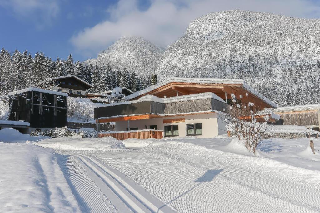 a building in the snow with mountains in the background at Alte Zimmerei - Lofer in Lofer