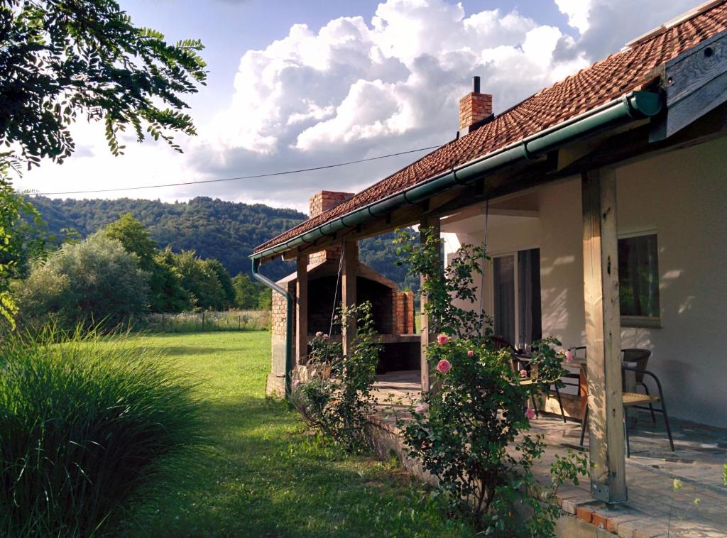una pequeña casa blanca con una silla en un patio en Holiday Home Dvoslap, en Bihać