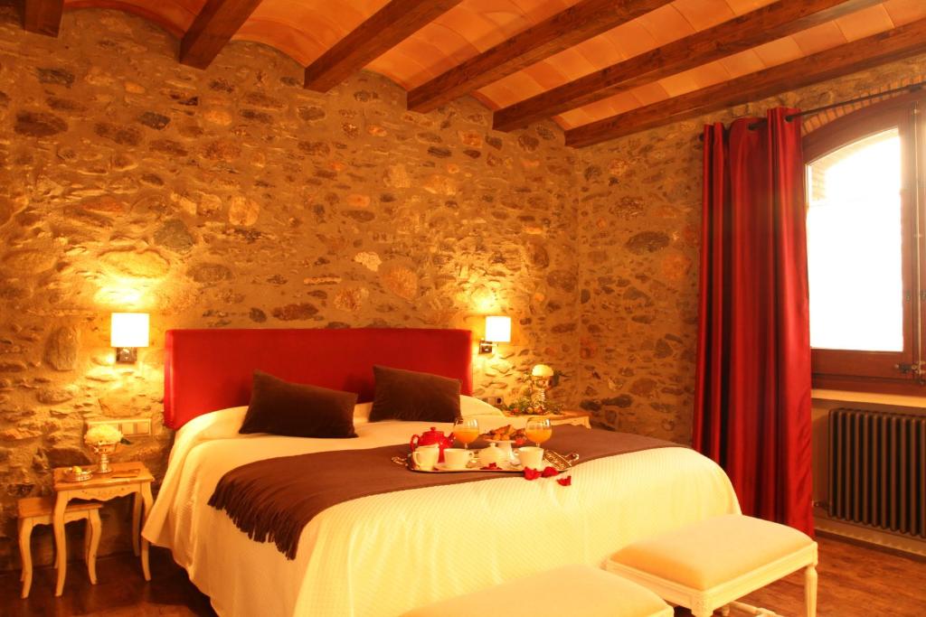 a bedroom with a bed with a tray of fruit on it at Hotel Rural Can Vila in Sant Esteve de Palautordera