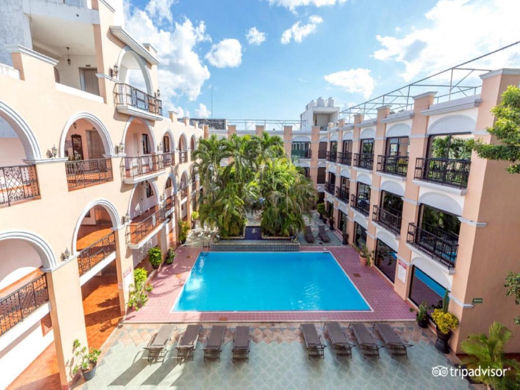 an apartment with a swimming pool in a building at Hotel Doralba Inn in Mérida