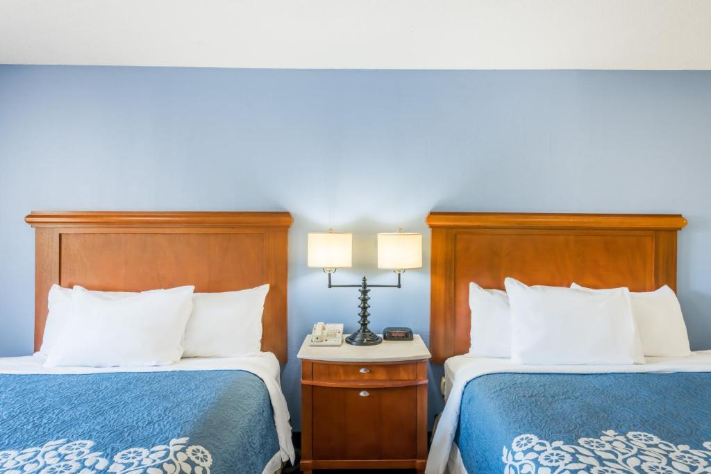 two beds in a hotel room with blue walls at Aderi Hotel Near Casino in Niantic