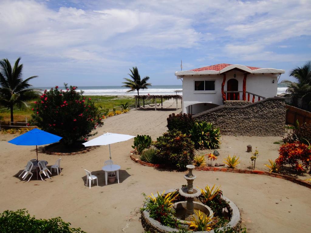 un edificio en la playa con sillas y una fuente en Sundown Beach Hotel, en Canoa