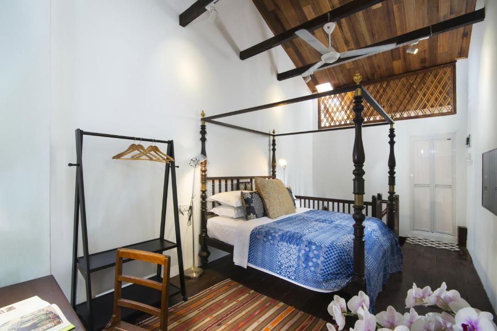 a bedroom with a canopy bed and a table at Jawi Peranakan Mansion in George Town