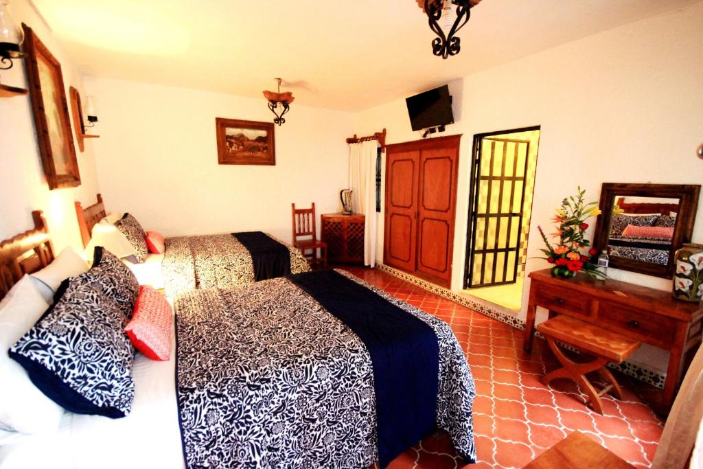 Habitación de hotel con 2 camas y escritorio en Hotel Mesón del Rosario en Guanajuato