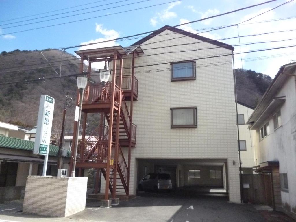 uma casa com uma escada de madeira ao lado em Sudomari Hotel Roman Tsutsuji em Nikko