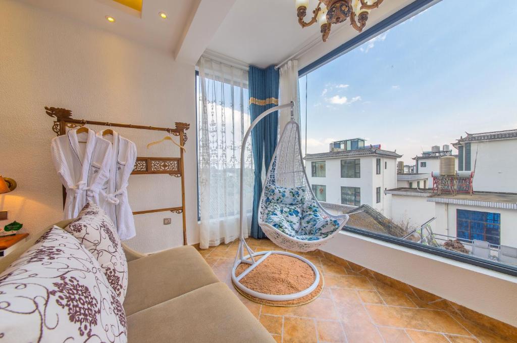 ein Wohnzimmer mit einer Hängematte und einem großen Fenster in der Unterkunft Mengyuanju Boutique Inn in Dali