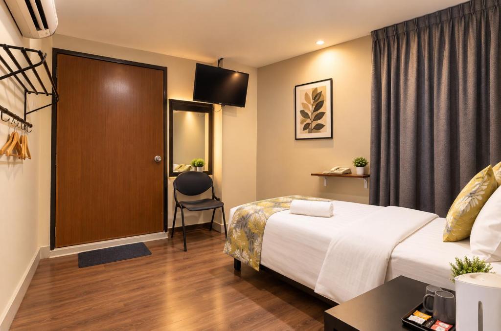A double room with a bed, television and curtained window wall.