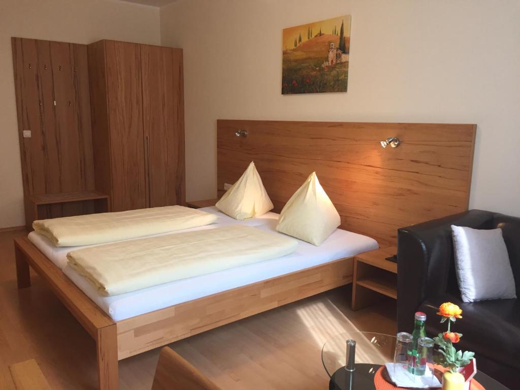 Schlafzimmer mit einem Bett mit einem Kopfteil aus Holz in der Unterkunft Gasthaus Hotel Feldschlange in Ried im Innkreis