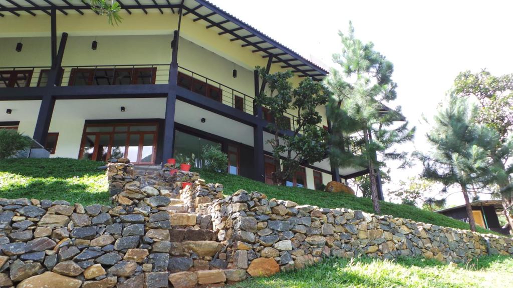 eine Steinmauer vor einem Haus in der Unterkunft Grace Holiday Bungalow in Haputale