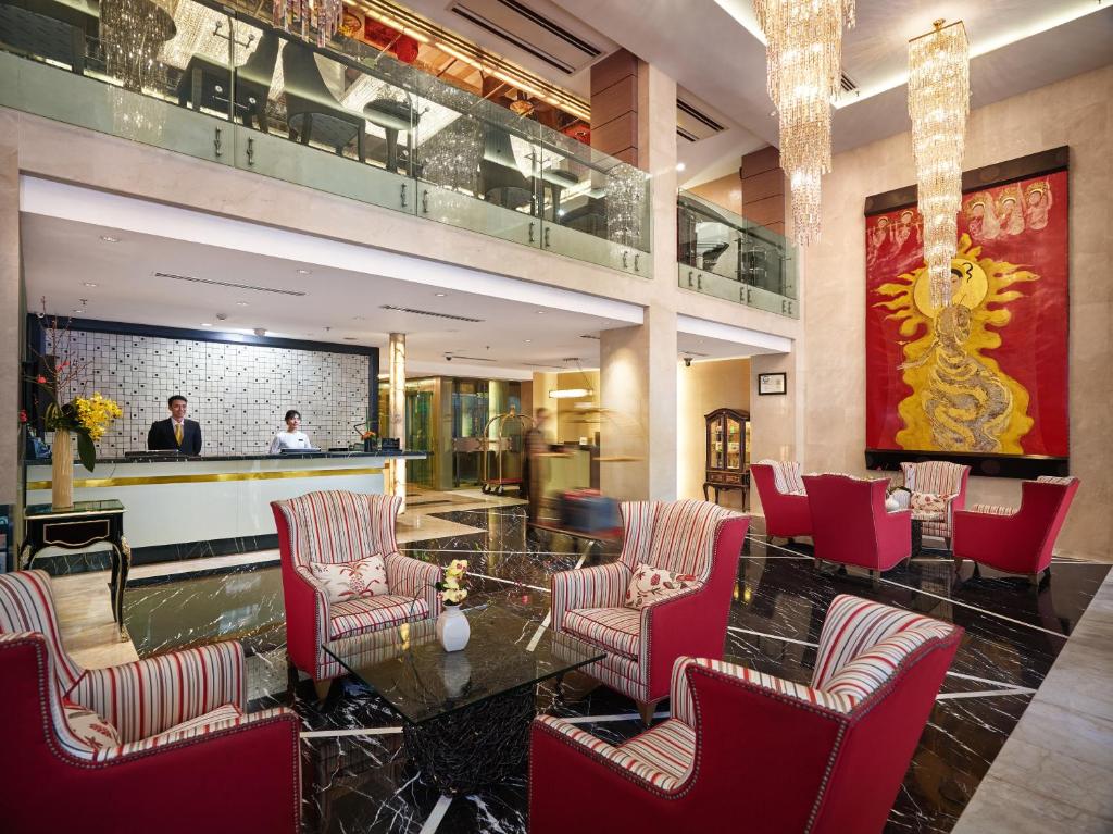 a lobby with red chairs and a table and a bar at Silk Path Hanoi Hotel in Hanoi