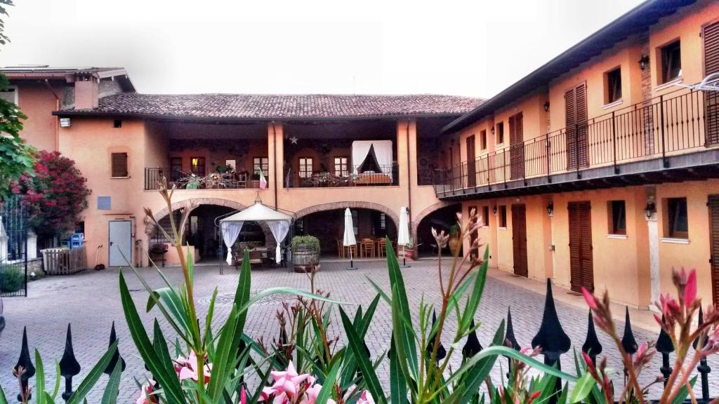 a building with a courtyard with flowers in front of it at Agriturismo SANGALLO in bedizzol