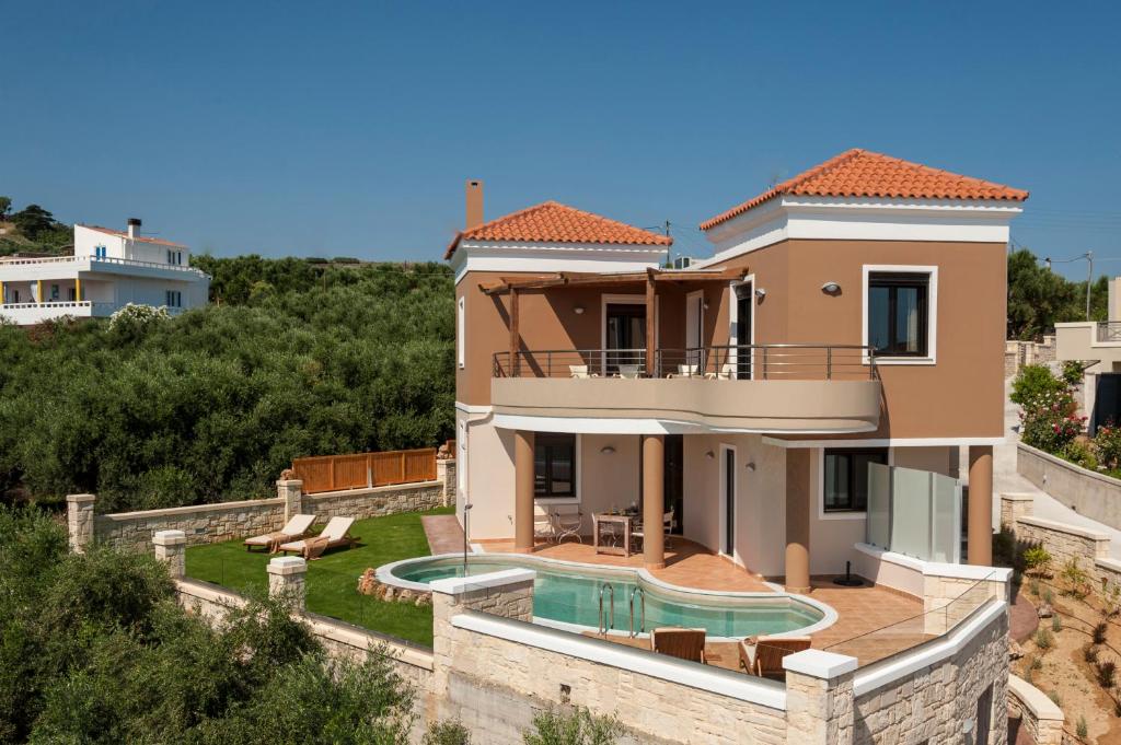 a villa with a swimming pool and a house at Villa Stellina in Marathokefála