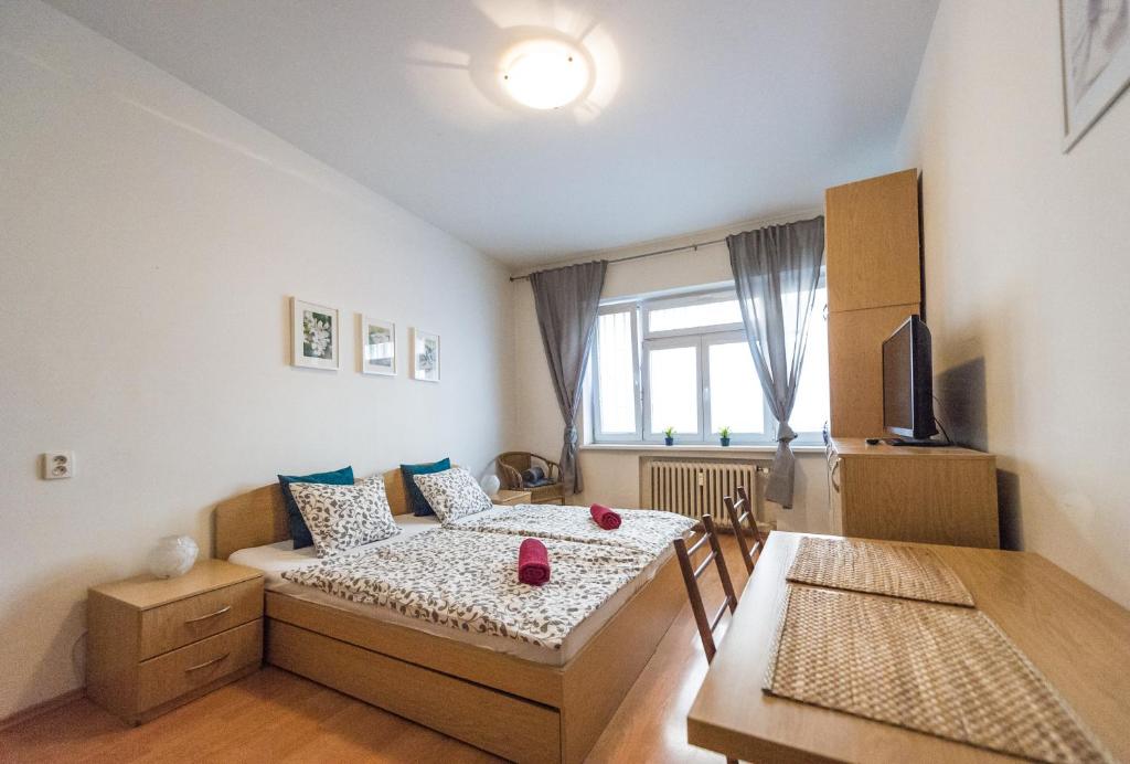 Kleines Zimmer mit einem Bett und einem Esstisch in der Unterkunft Apartments Presidential Palace in Bratislava