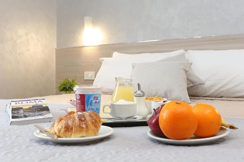 einen Tisch mit zwei Teller Essen auf einem Bett in der Unterkunft AdoraSuite 2 in Rom