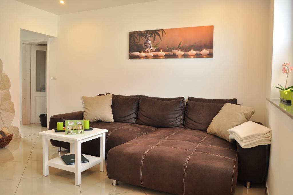 ein Wohnzimmer mit einem braunen Sofa und einem Tisch in der Unterkunft Ferienwohnungen Gehlberg in Gehlberg