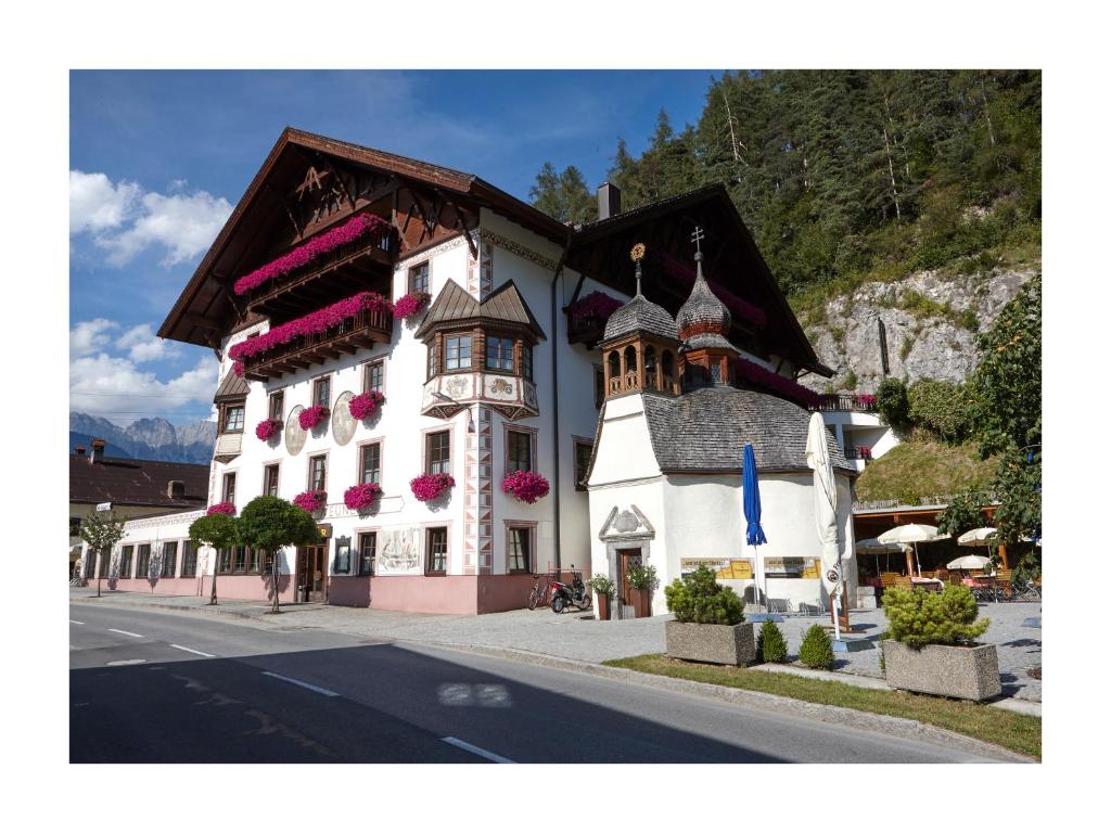 un grand bâtiment blanc avec une horloge. dans l'établissement Hotel Gasthof Neuner, à Imst